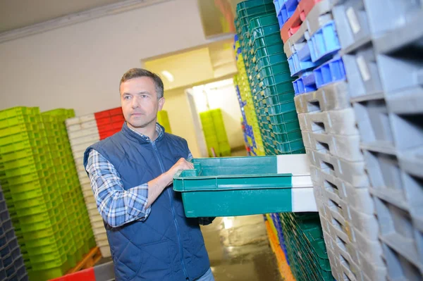 Pracownik Wybierając Kolor Kodowane Plastikowe Skrzynki — Zdjęcie stockowe