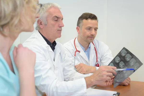 Команда врачей смотрит на рентген в конференц-зале — стоковое фото