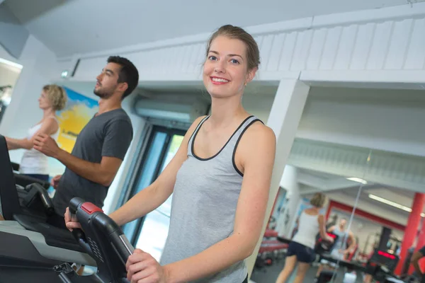 Pessoas positivas formação sobre as bicicletas de exercício no clube de fitness — Fotografia de Stock