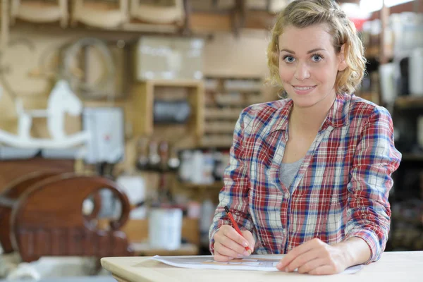 Portrait of woman sat at table in workshop — Stock Photo, Image