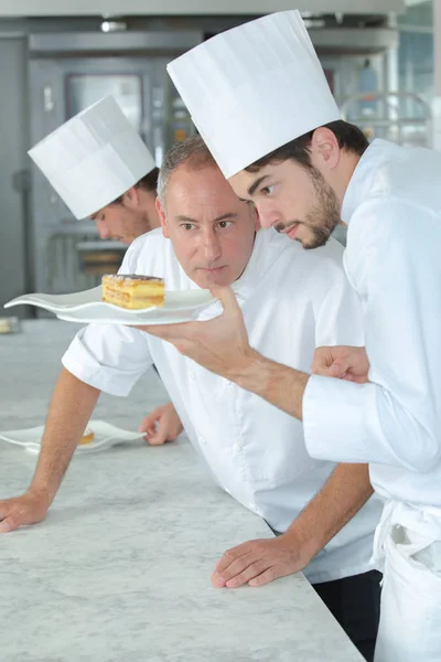 Пекарь инструктирует ученика и кондитера — стоковое фото