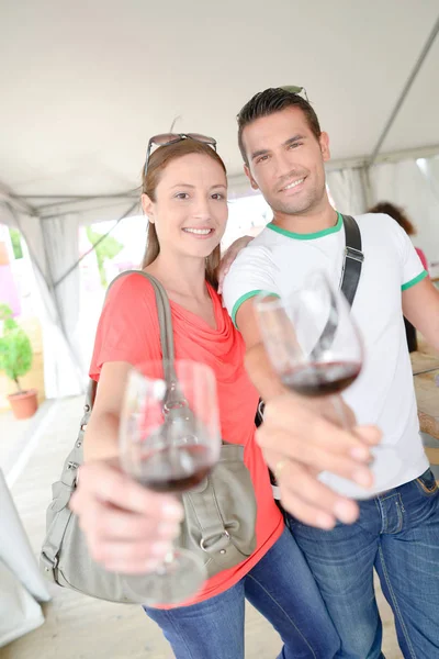 Paar hält jeweils ein Glas Wein in ausgestrecktem Arm — Stockfoto