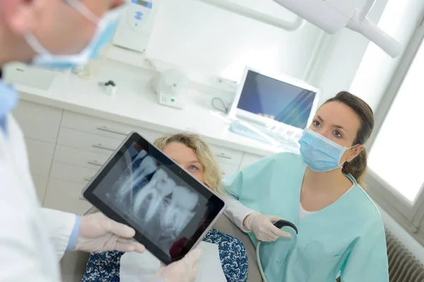 Zubař s RTG zubů na tabletu s sestra a pacient — Stock fotografie