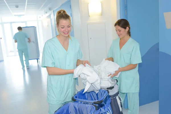 female workers changing hospital sheets