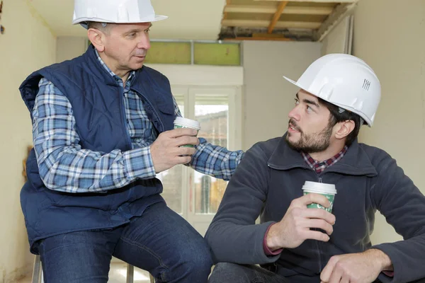 Trabajadores de la construcción felices sosteniendo tazas de café desechables — Foto de Stock