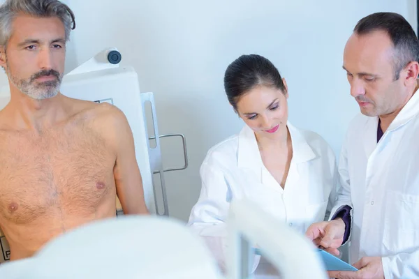 Medics with undressed middle aged man — Stock Photo, Image