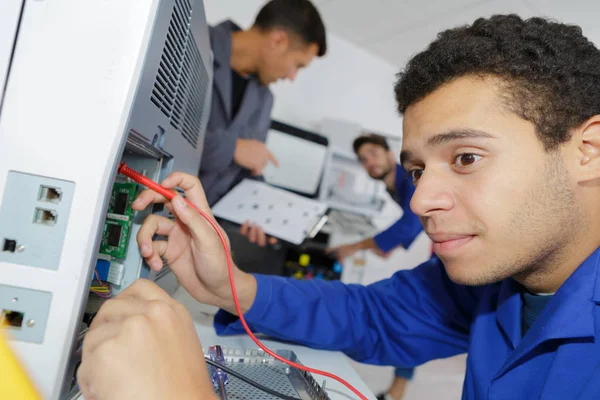 Молодий ремонтник працює в центрі комп'ютерного обслуговування — стокове фото