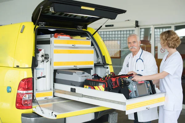 Sanitäter laden Ausrüstung in Rettungswagen — Stockfoto