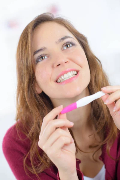 Smiling woman looking on pregnant test — Stock Photo, Image