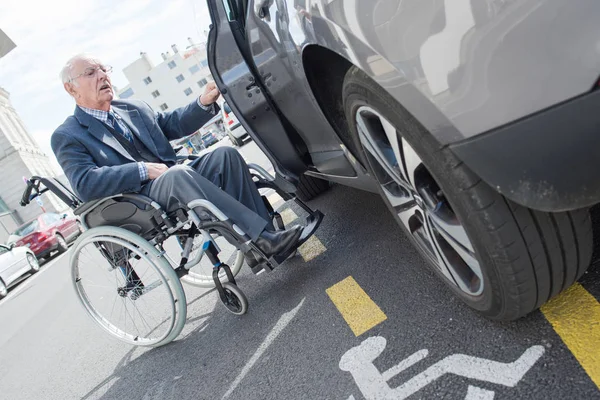 Homme en fauteuil roulant à côté de sa voiture — Photo