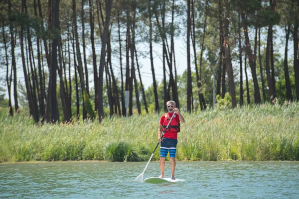 Man genieten van een ritje op het meer met paddleboard — Stockfoto