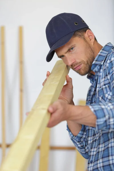 Carpintero trabajando en un tablón de madera en su taller — Foto de Stock