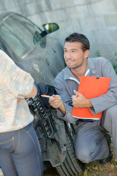 Asesoramiento mecánico cliente y joven — Foto de Stock