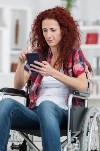 Disabled woman wheel chair and typing message with smartphone — Stock Photo, Image