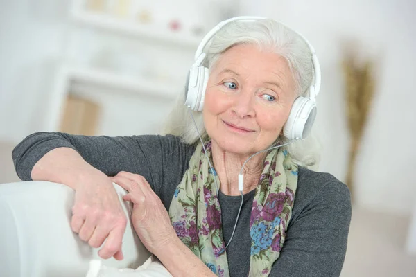 Ältere Dame hört gerne Kopfhörer — Stockfoto