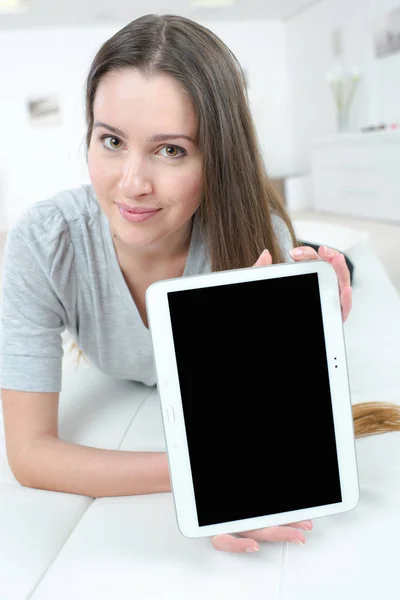 Imagem mostrando mulher feliz com tablet no sofá — Fotografia de Stock