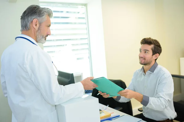 Médico en consulta con el paciente masculino —  Fotos de Stock