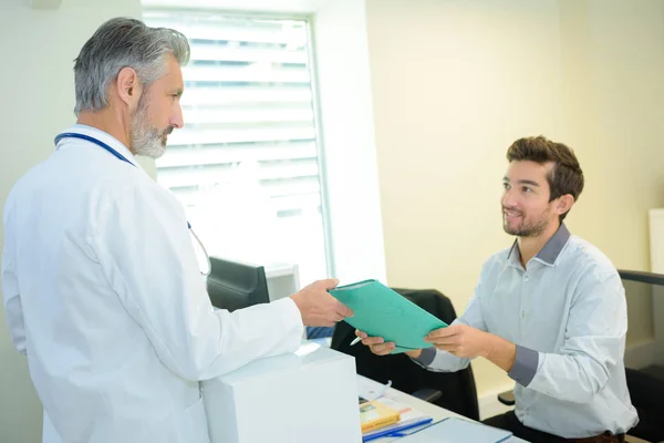 Läkare i samråd med manlig patient — Stockfoto