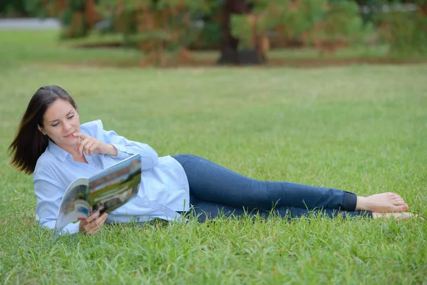 Vrouw liggend op het gras — Stockfoto