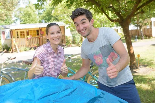 Paar ophangen van tent, positieve thums up gebaar maken — Stockfoto