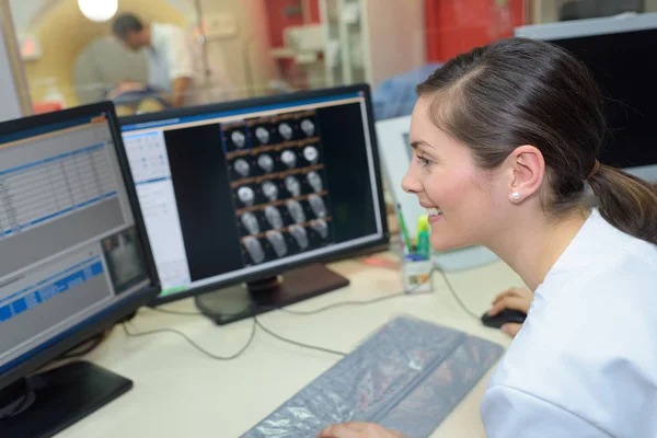 Médico atentamente mira a los resultados de rayos X cerebrales mans — Foto de Stock