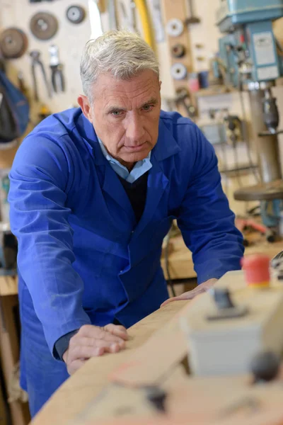 Carpintero senior está perforando tablones de madera — Foto de Stock