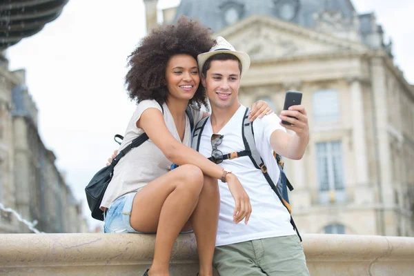 Vista di una giovane coppia in vacanza scattando selfie — Foto Stock