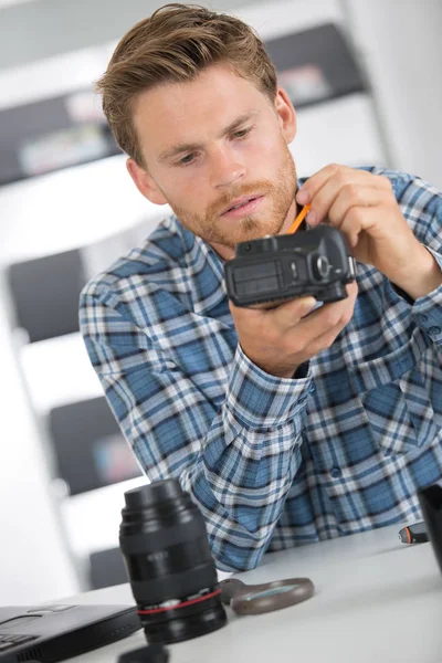 Fotograf putzt Kamera mit Pinsel — Stockfoto