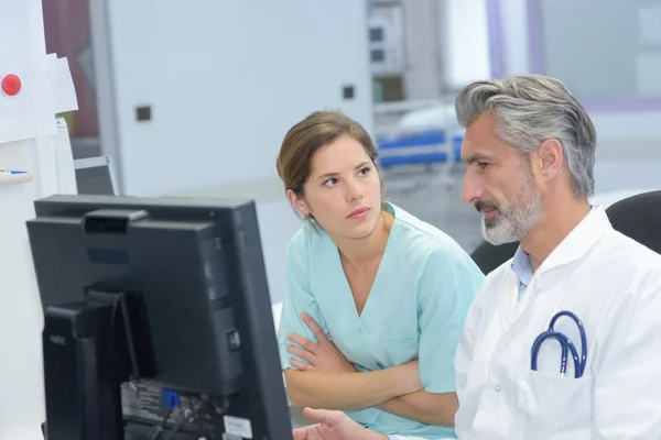 Médico y enfermera joven revisando los documentos del paciente — Foto de Stock