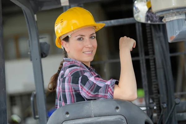 Trabajadora operando carretilla elevadora en astillero — Foto de Stock