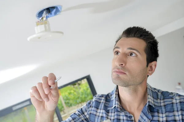 Man fitting spotlight in ceiling — Stock Photo, Image