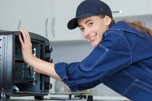 Vrouw die op teller boven oven werkt — Stockfoto