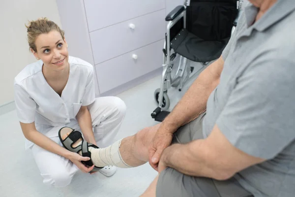 Krankenschwester massiert den Fuß des Patienten — Stockfoto