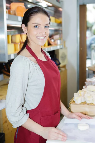 Retrato de vendedora feliz na loja de queijo — Fotografia de Stock