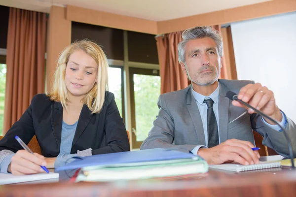 Mann und Frau am Schreibtisch mit Mikrofon — Stockfoto