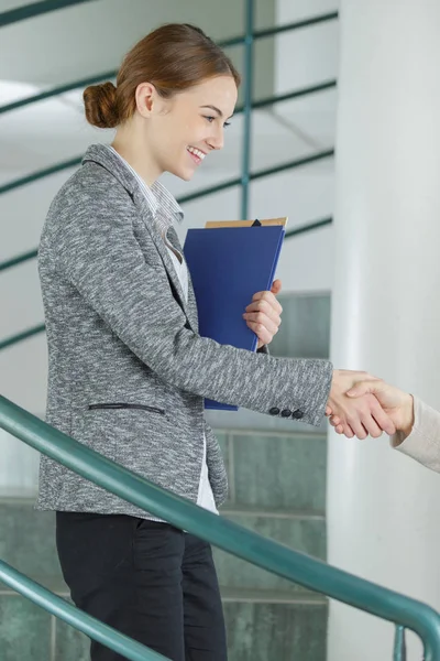Female manager shaking hands with customer — Stock Photo, Image