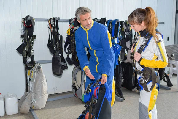Monitor de paracaidismo y estudiante preparándose en el hangar —  Fotos de Stock
