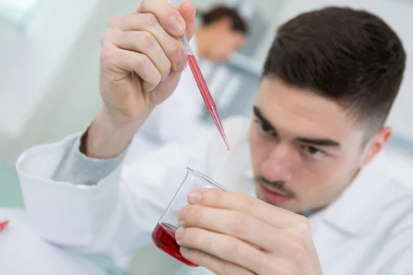 Añadir una pequeña gota de sustancia química —  Fotos de Stock