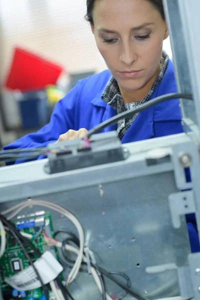 Vrouwelijke technicus die een printer repareert — Stockfoto
