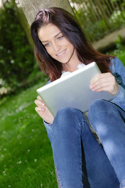 Pretty student using digital tablet outdoors Stock Picture