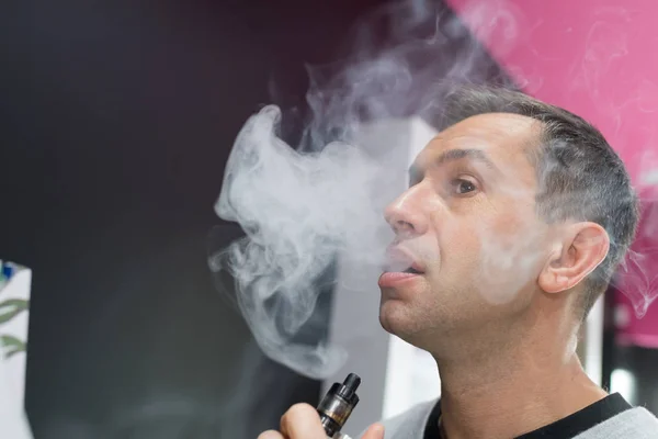 Az elektronikus cigaretta füstöt burkolva ember — Stock Fotó