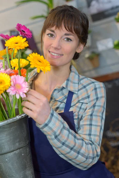Szczęśliwa kobieta jak dbać o kwiaty w sklepie — Zdjęcie stockowe