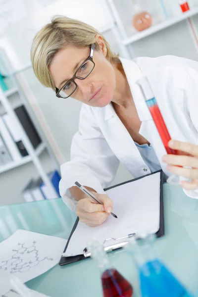 Closeup of beautiful lab worker holding up test tube — Stock Photo, Image