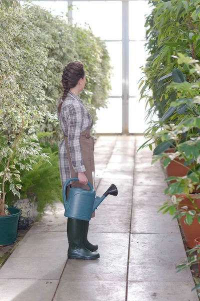 Frau in Gartencenter mit Gießkanne — Stockfoto