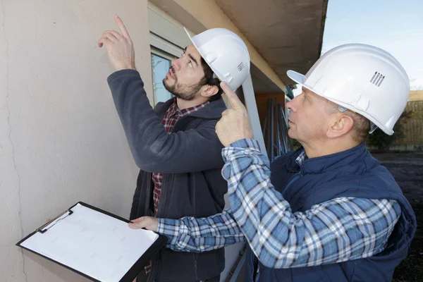Dos ingeniero mostrando plan de construcción capataz —  Fotos de Stock
