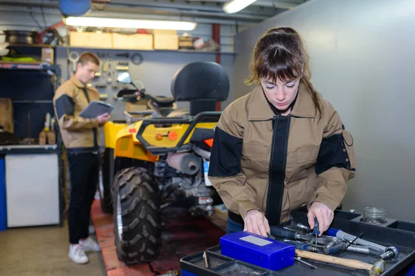 Arbeiterin repariert Traktormotor mit dem Schraubenschlüssel — Stockfoto