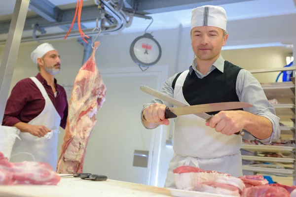 Metzger schärft Messer mit einem Stahl — Stockfoto