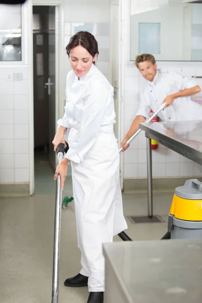 Άνδρας και γυναίκα καθαρίζοντας πάτωμα στην κουζίνα profesional — Φωτογραφία Αρχείου