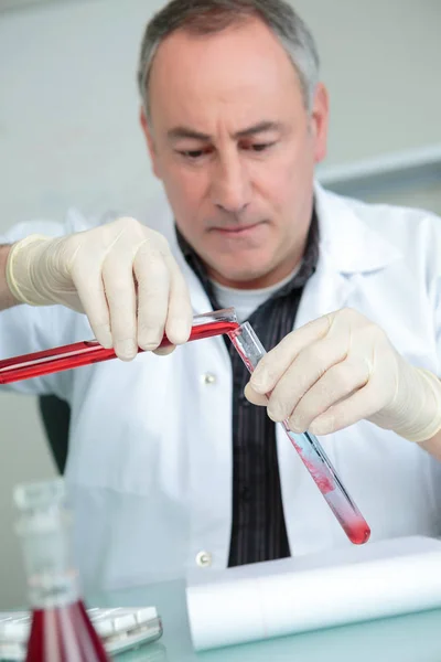 Científico llenando un frasco en un laboratorio químico — Foto de Stock