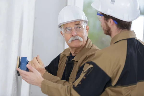 Manliga byggnadsarbetare smoothing väggytan — Stockfoto